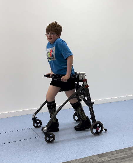 Cerebral palsy patient walking in gait lab in his ankle foot orthoses and walking frame